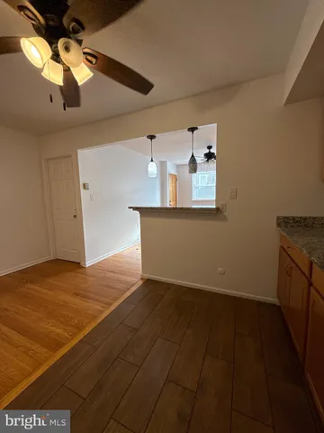 a view of a room with wooden floor and ceiling fan
