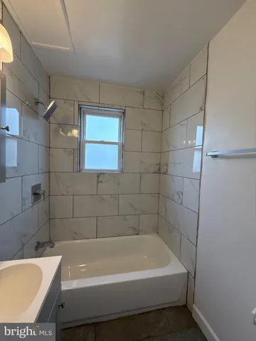 a bathroom with a tub a toilet and a shower