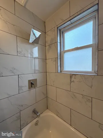 a bathroom with a bathtub and next to a window