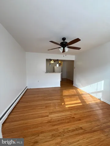 a view of a room with a ceiling fan and wooden floor