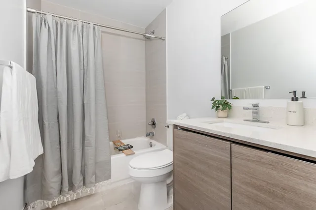 a bathroom with a sink a toilet and shower curtain