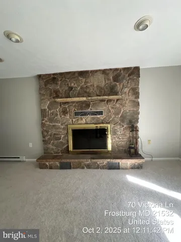 a view of an empty room with a fireplace and a window
