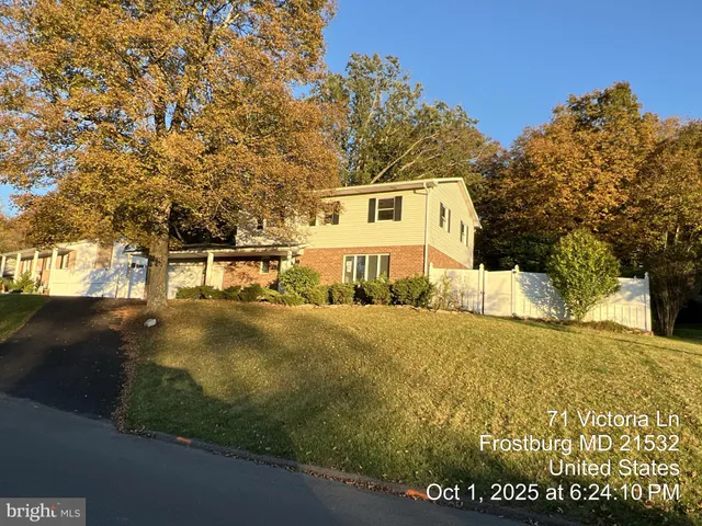 a view of a large white house with a yard