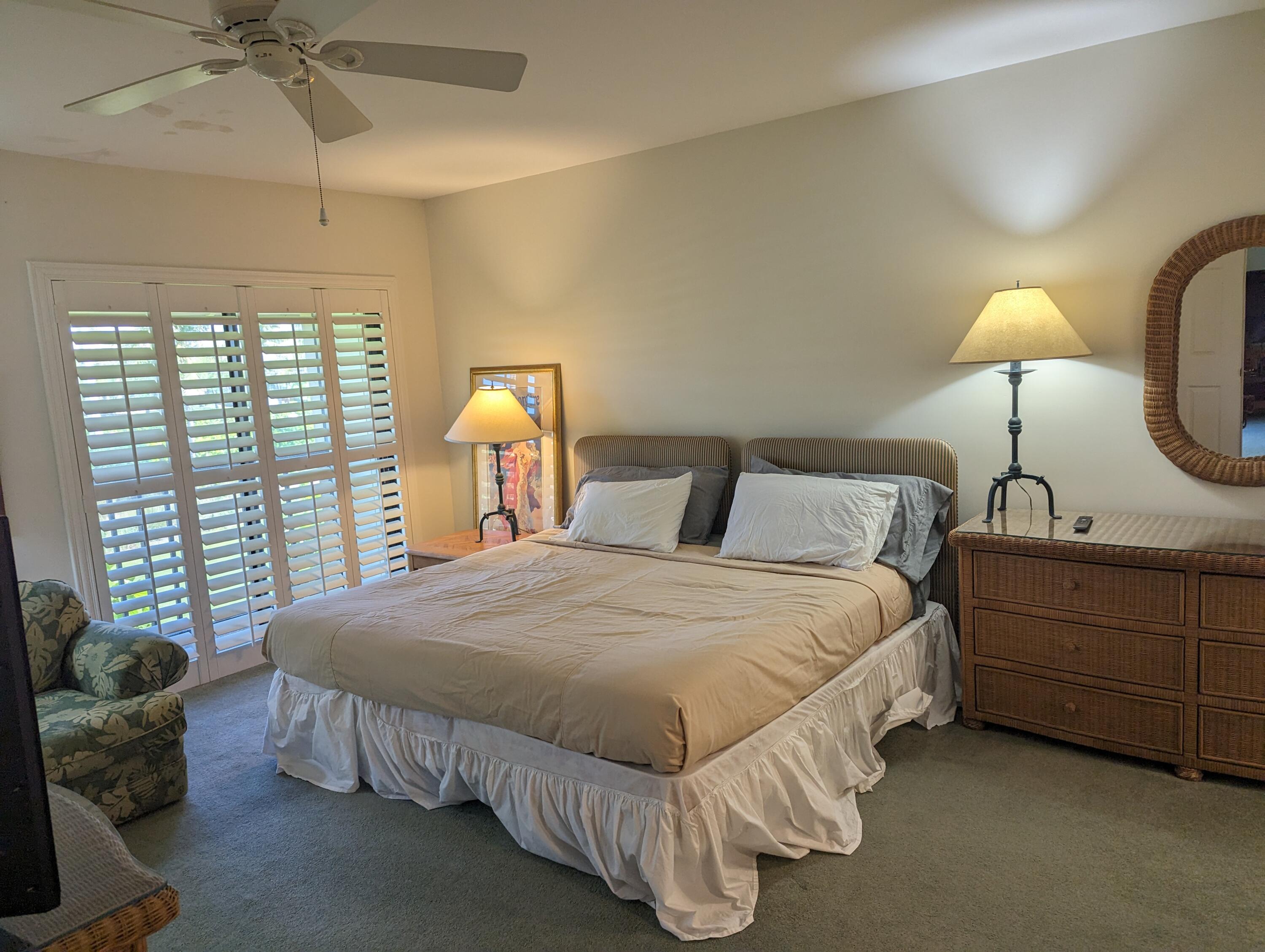 404 Clubhouse Circle Jupiter, FL 33477 - Photo 16 of 26 a bedroom with a bed and a chandelier