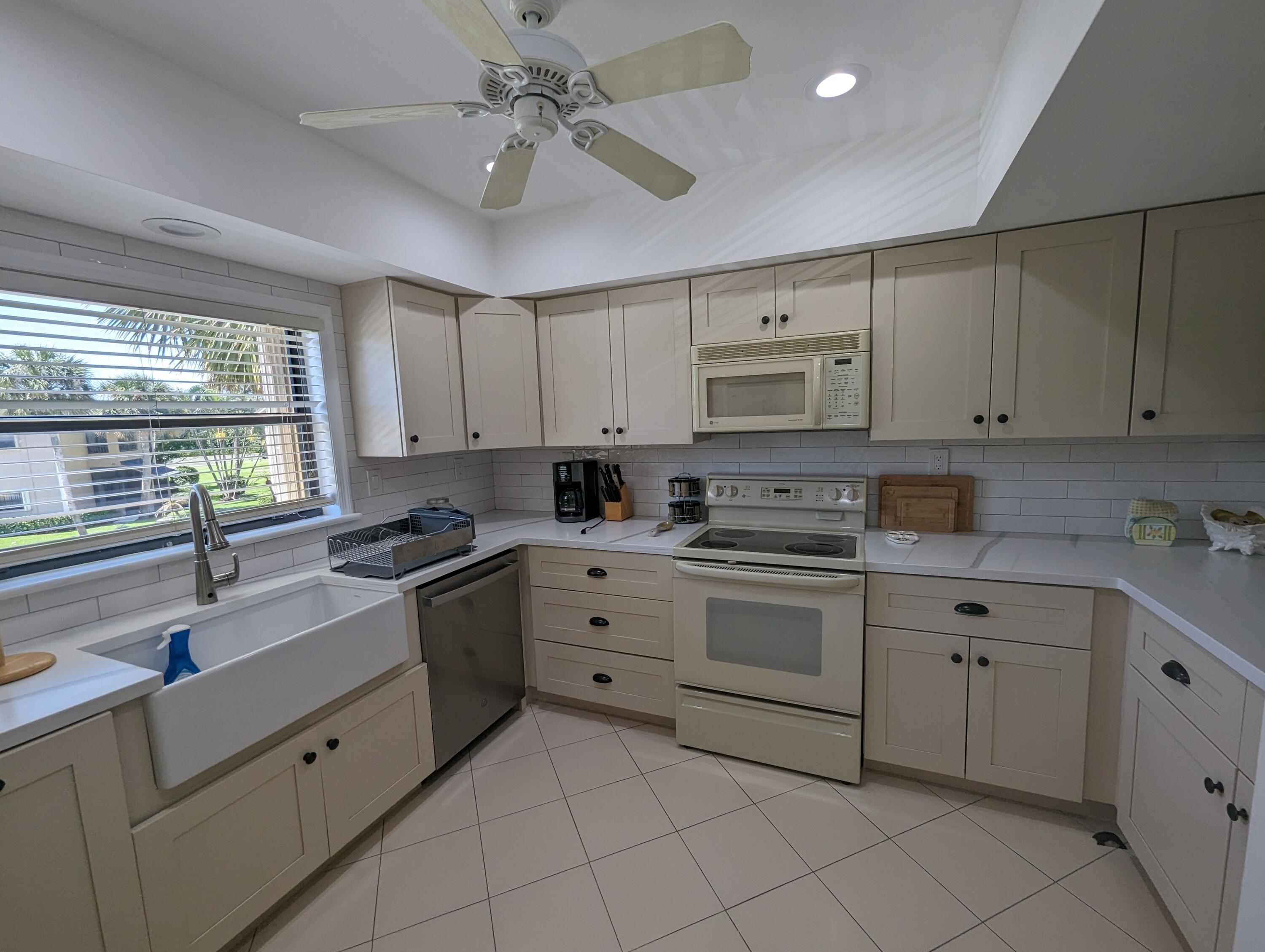 404 Clubhouse Circle Jupiter, FL 33477 - Photo 3 of 26 a kitchen with cabinets appliances a sink and a window