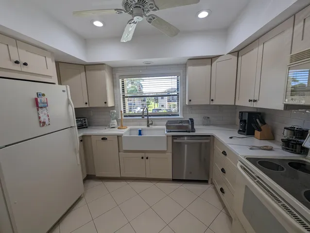 a kitchen with a white cabinets and white appliances
