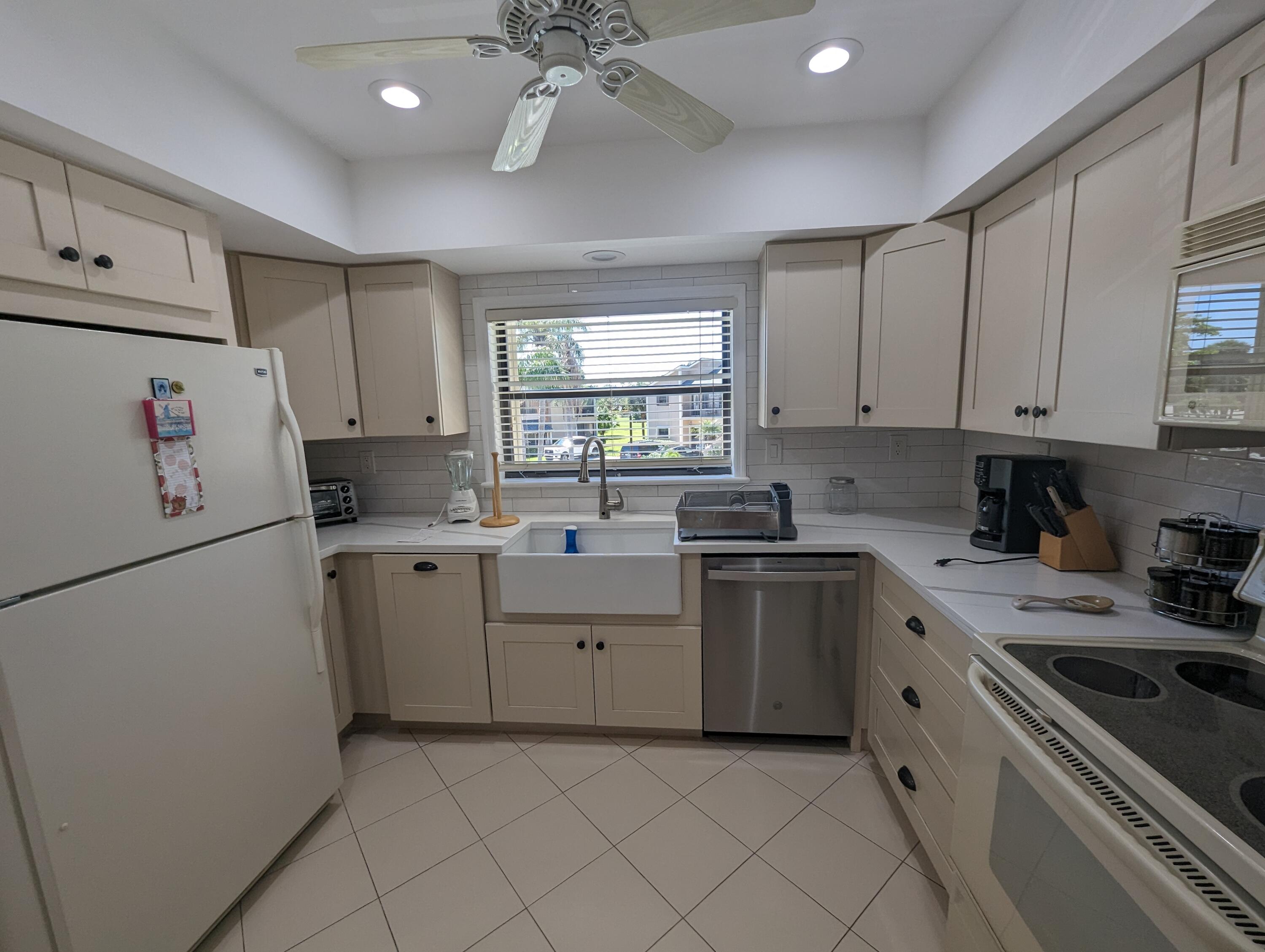 404 Clubhouse Circle Jupiter, FL 33477 - Photo 6 of 26 a kitchen with a white cabinets and white appliances