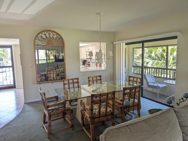 a dining room with furniture a chandelier and wooden floor