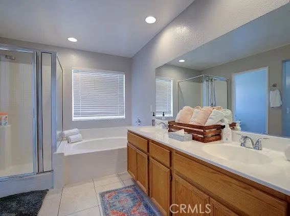 a bathroom with a tub sink double vanity granite and shower