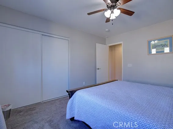 a bedroom with a bed and a chandelier fan
