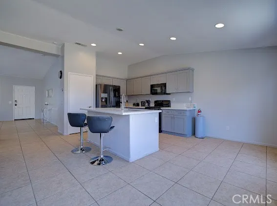 a kitchen with a refrigerator a sink a counter top space and cabinets