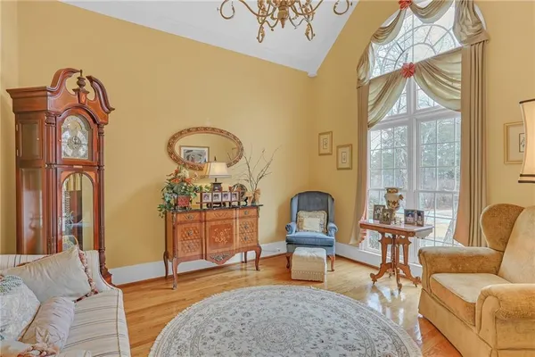 a living room with furniture a rug a fireplace and a large window