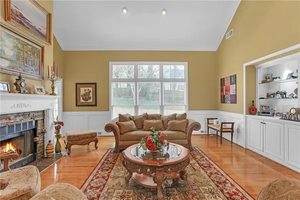 a living room with furniture a fireplace a lamp and a large window