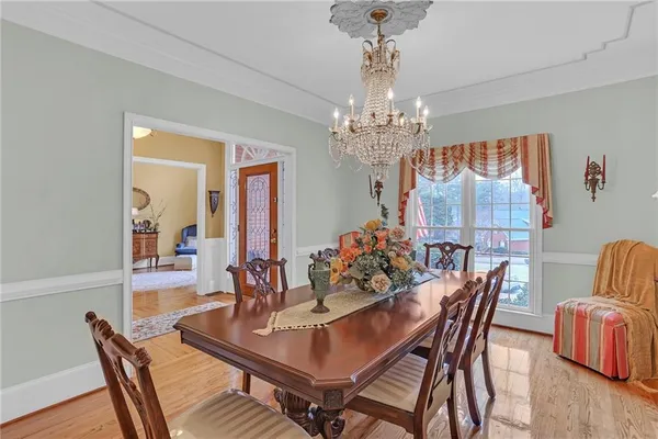 a view of a dining room with furniture wooden floor and chandelier
