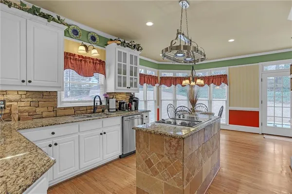a very nice looking kitchen with granite countertop a stove sink and cabinets