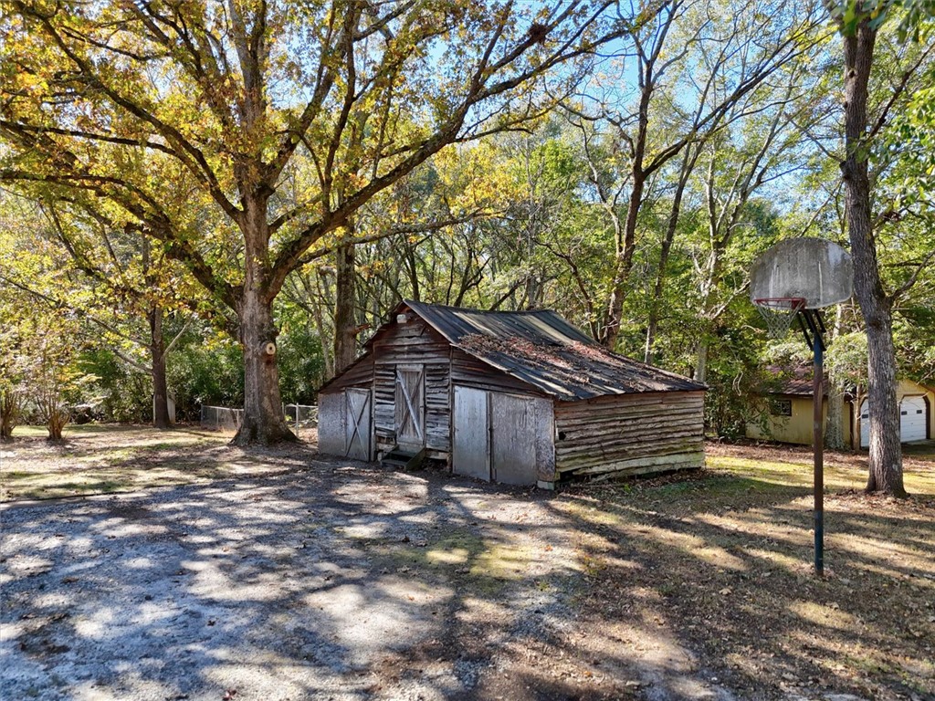 0 Cromer Road, Unit 245 CROMER ROAD Williamston, SC 29697 - Photo 11 of 24 This tranquil yard features a rustic shed and a basketball hoop, surrounded by mature trees.