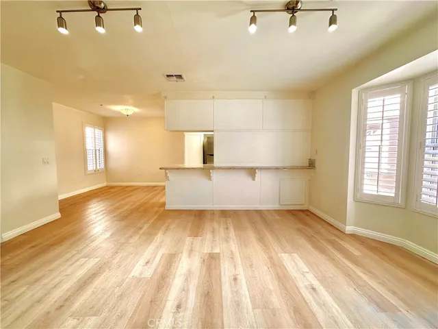 a view of a bedroom with a window and wooden floor