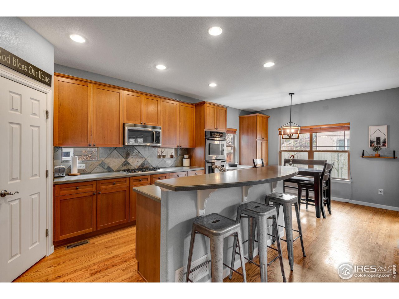 4115 Frederick Circle Longmont, CO 80503 - Photo 14 of 39 a kitchen with stainless steel appliances granite countertop wooden cabinets a dining table and chairs