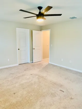 a bedroom with a bed and a ceiling fan