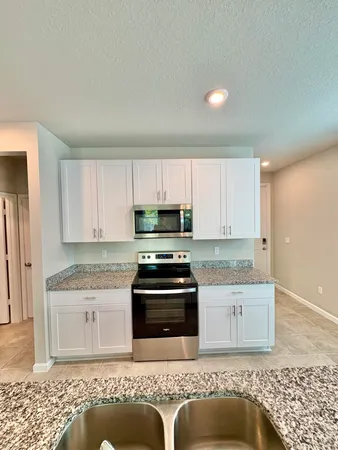 a view of a room with wooden floor and ceiling fan
