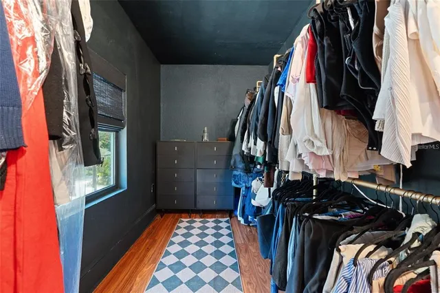 a view of walk in closet with clothes and shoes