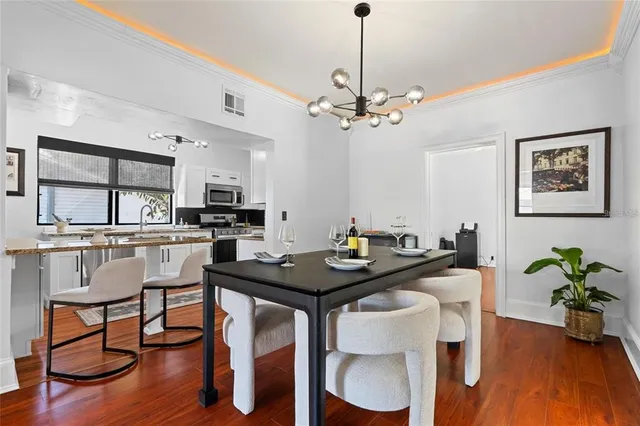 a view of a dining room with furniture wooden floor and chandelier