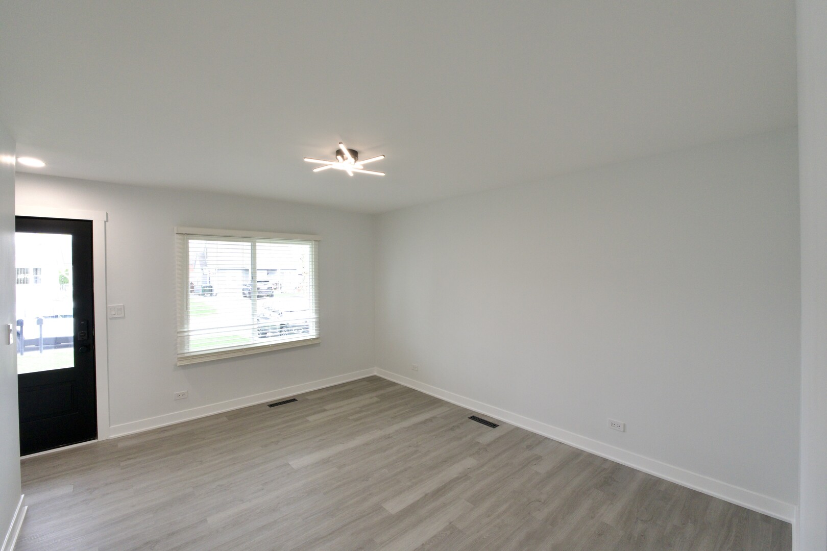 1406 Ridgeway Street Round Lake Beach, IL 60073 - Photo 11 of 33 an empty room with wooden floor and windows