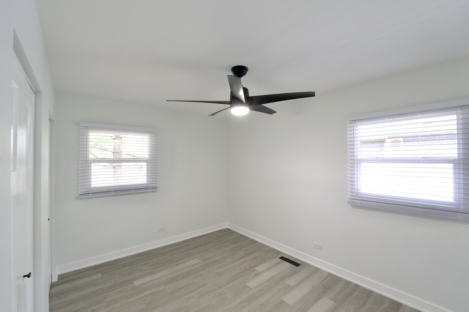 1406 Ridgeway Street Round Lake Beach, IL 60073 - Photo 18 of 33 an empty room with wooden floor ceiling fan and windows