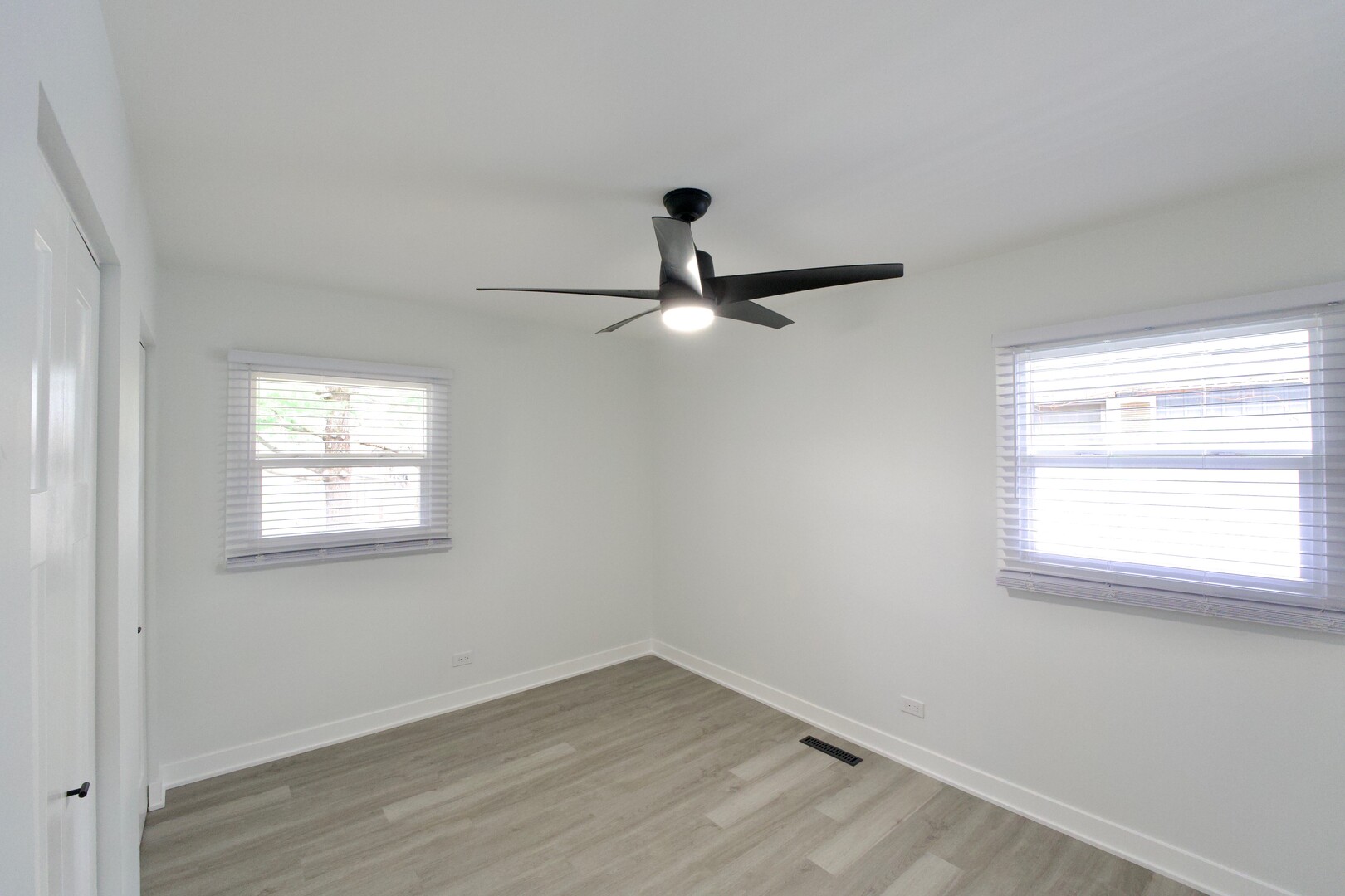 1406 Ridgeway Street Round Lake Beach, IL 60073 - Photo 22 of 33 an empty room with wooden floor ceiling fan and windows