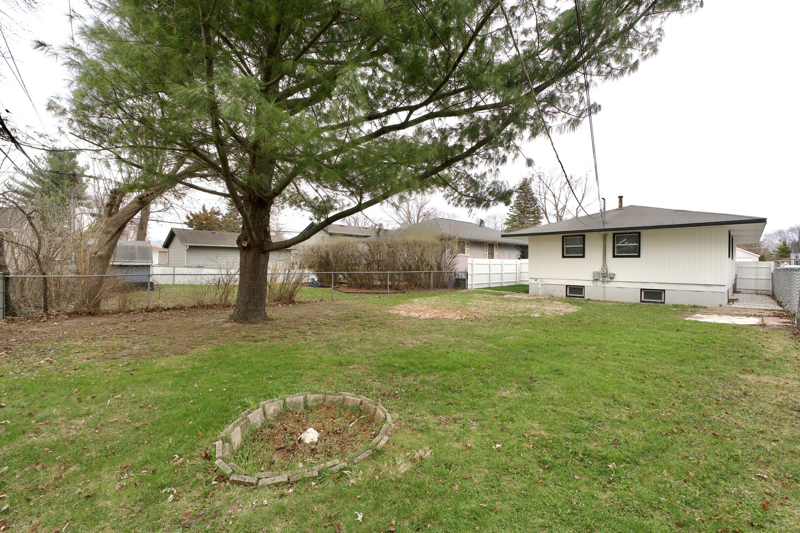 1406 Ridgeway Street Round Lake Beach, IL 60073 - Photo 32 of 33 a view of a white house with a big yard plants and large trees