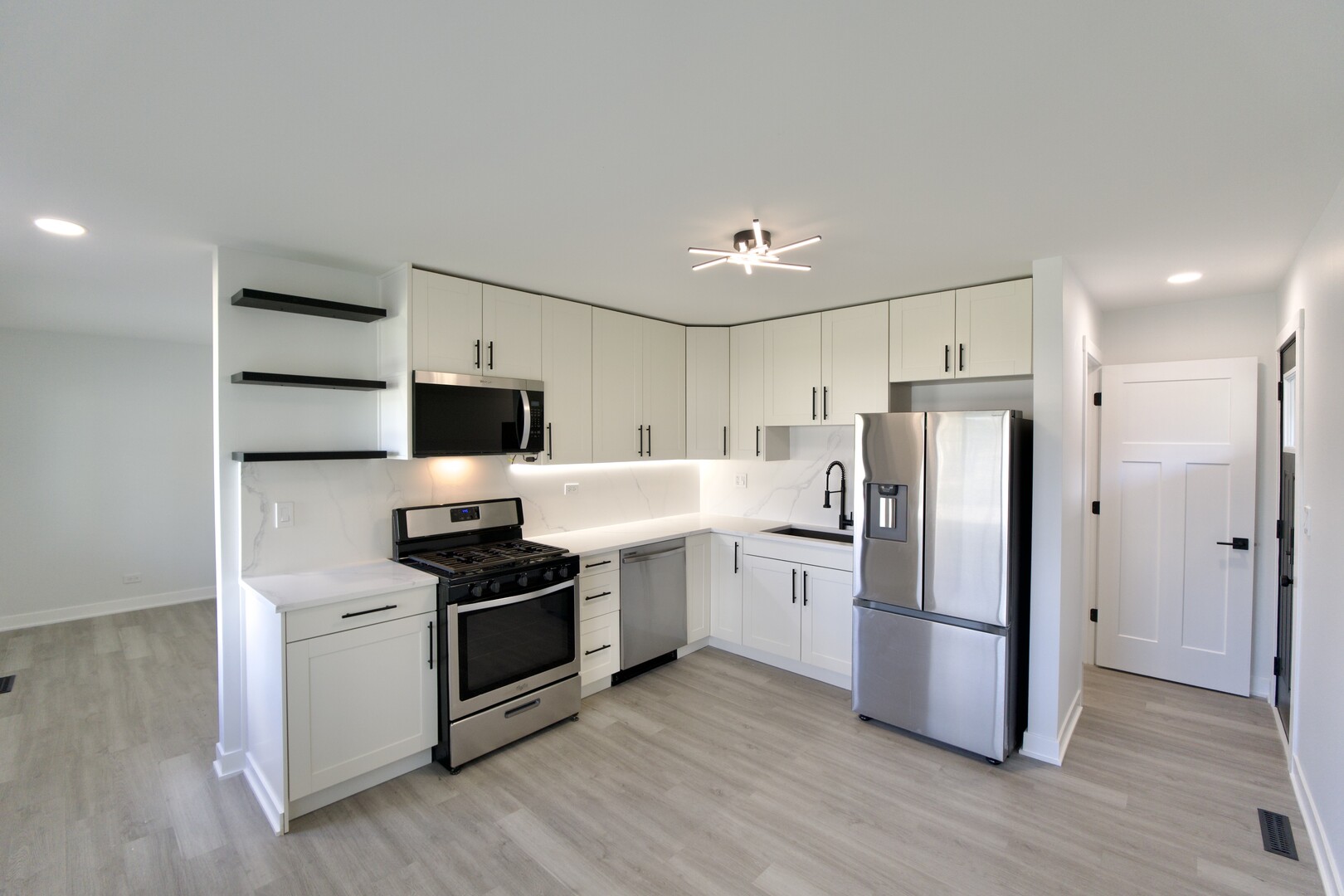 1406 Ridgeway Street Round Lake Beach, IL 60073 - Photo 5 of 33 a kitchen with stainless steel appliances a refrigerator and a stove top oven