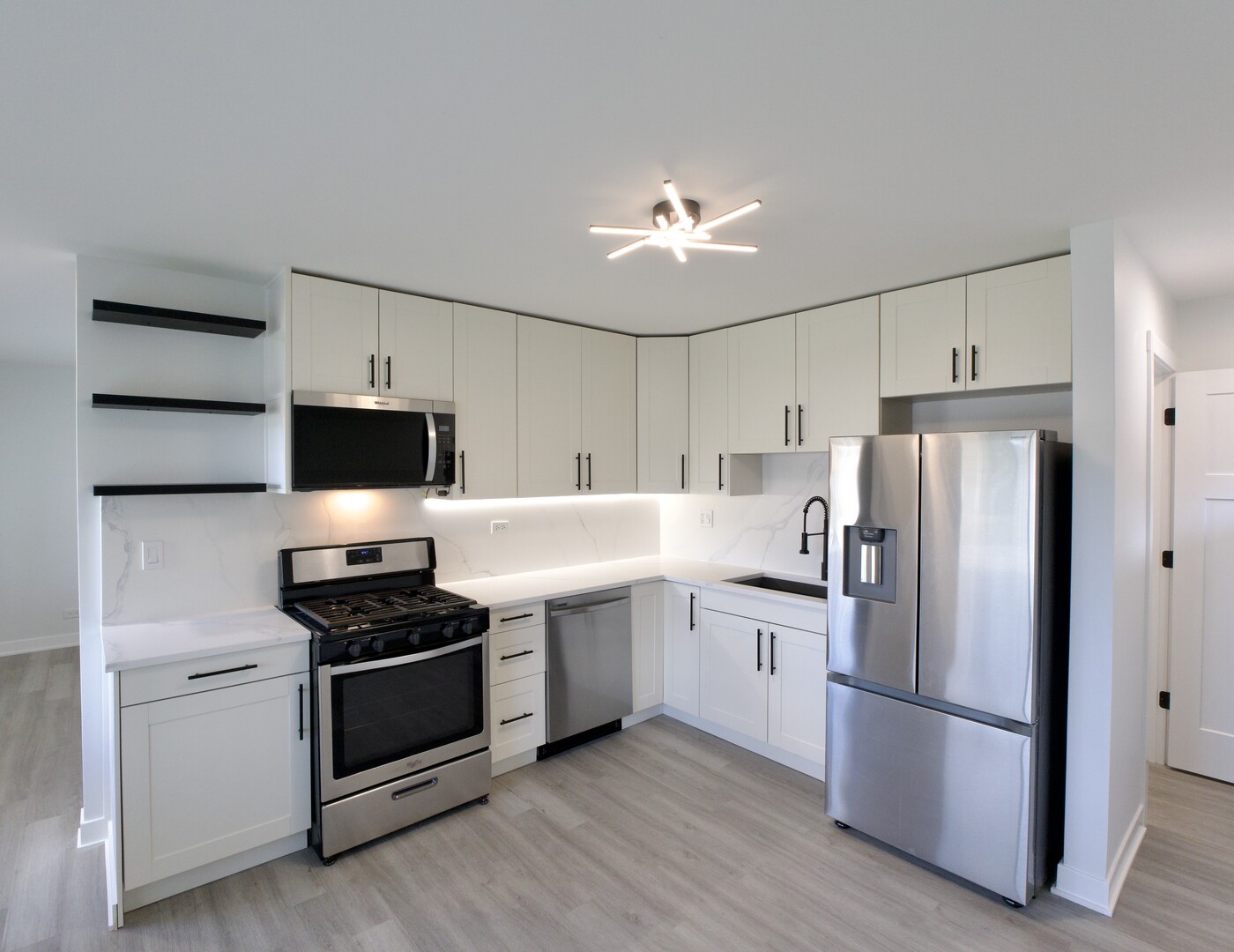 1406 Ridgeway Street Round Lake Beach, IL 60073 - Photo 7 of 33 a kitchen with stainless steel appliances a refrigerator stove and microwave