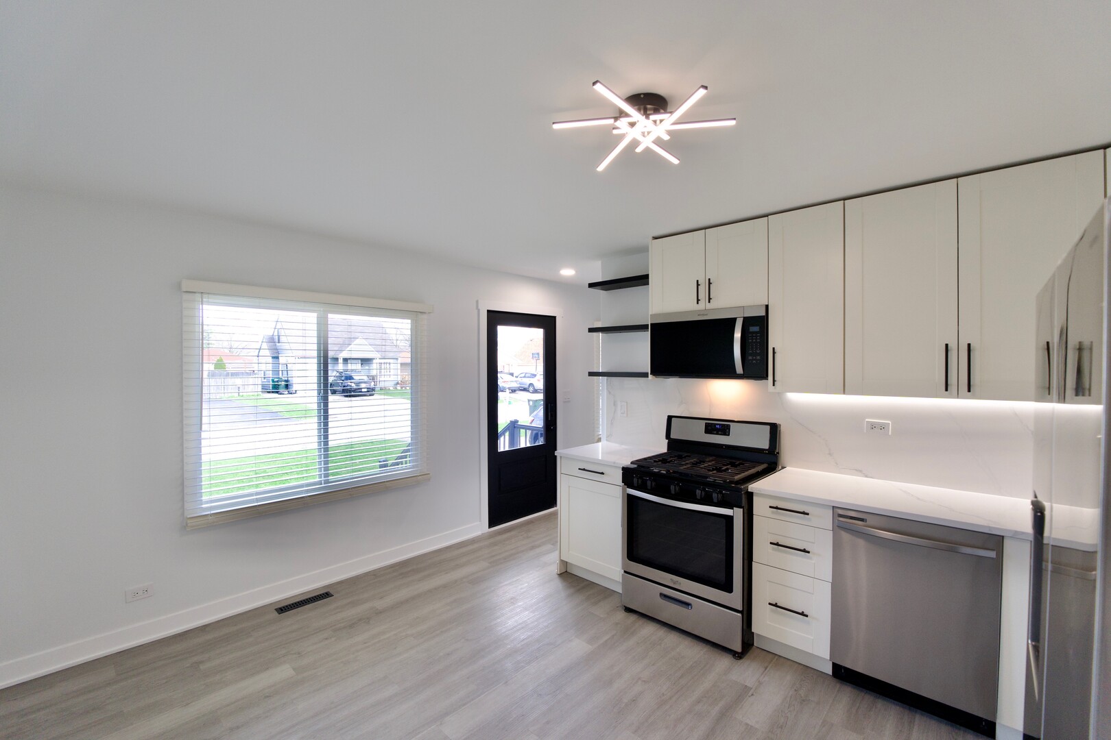 1406 Ridgeway Street Round Lake Beach, IL 60073 - Photo 8 of 33 a kitchen with stainless steel appliances white cabinets and window