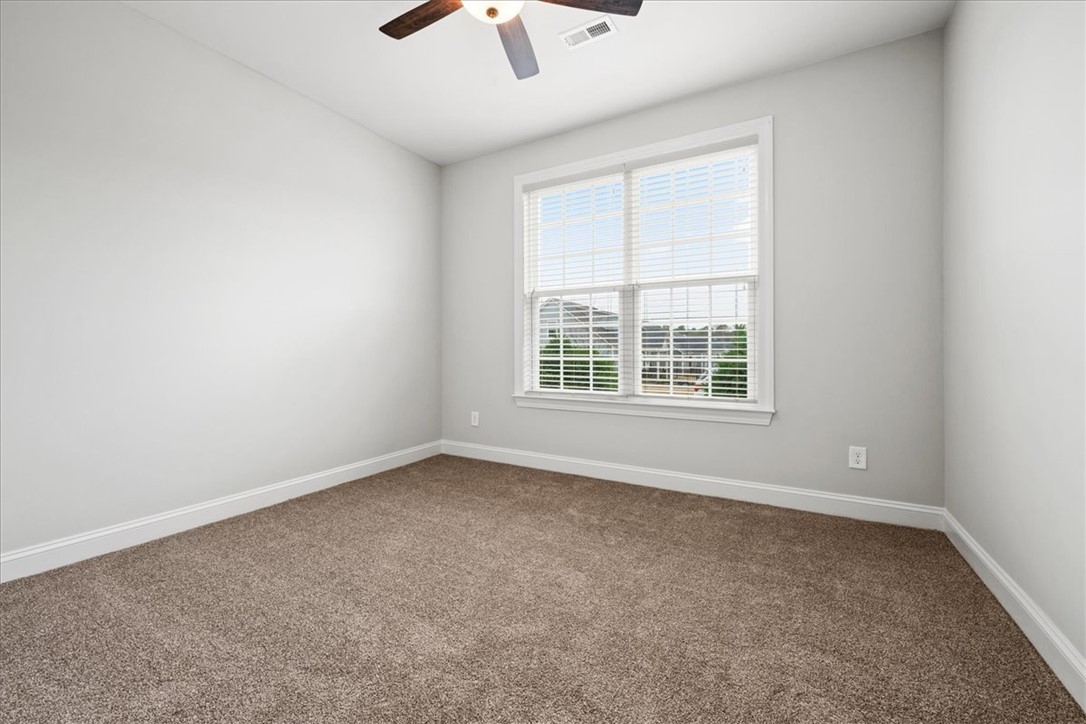 102 Ripplestone Way Anderson, SC 29621 - Photo 14 of 39 A well-lit bedroom features plush carpeting and a large window offering neighborhood views.