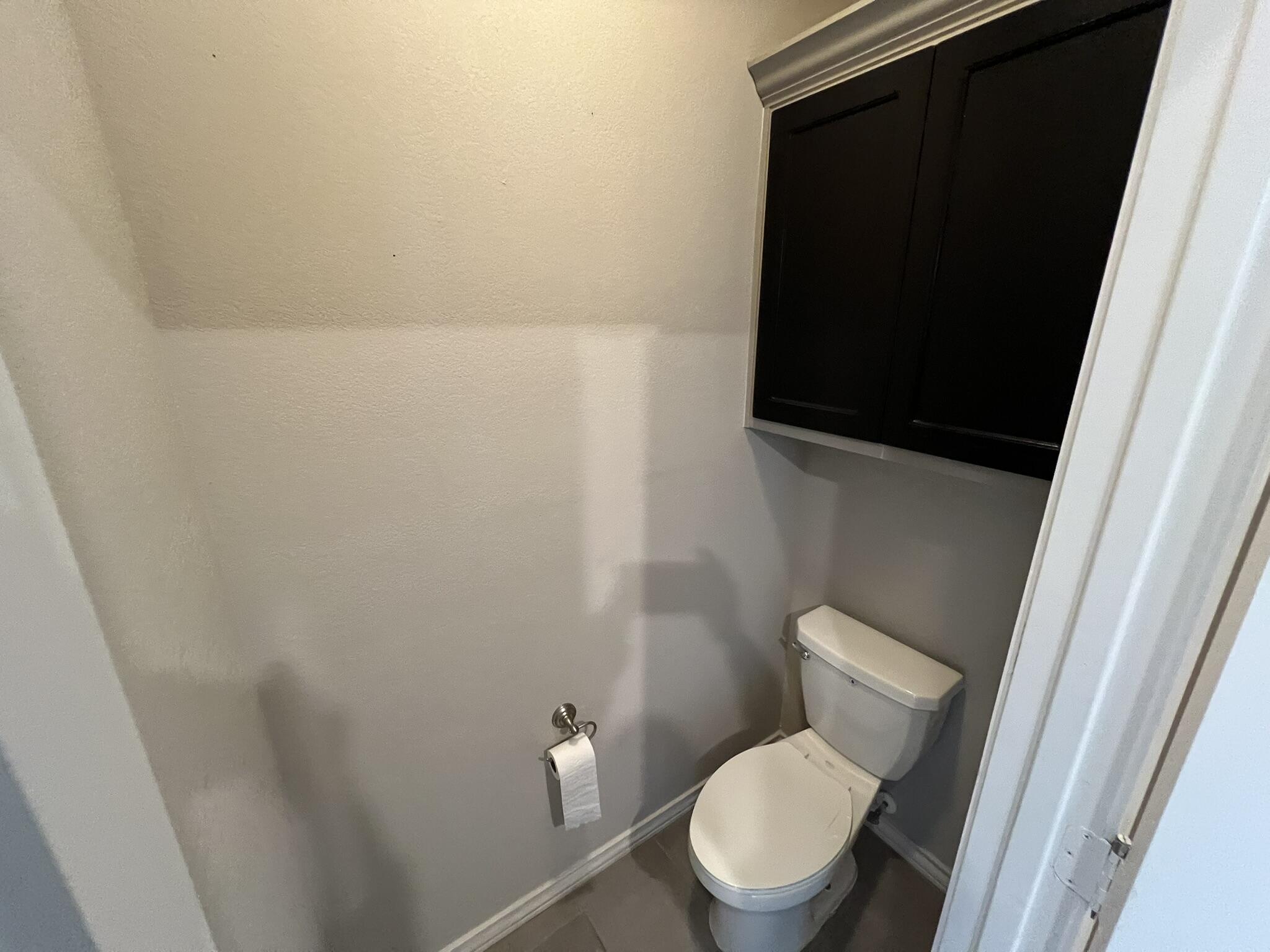 816 North 3rd Street Wolfforth, TX 79382 - Photo 20 of 28 a white toilet sitting next to a small wooden vanity