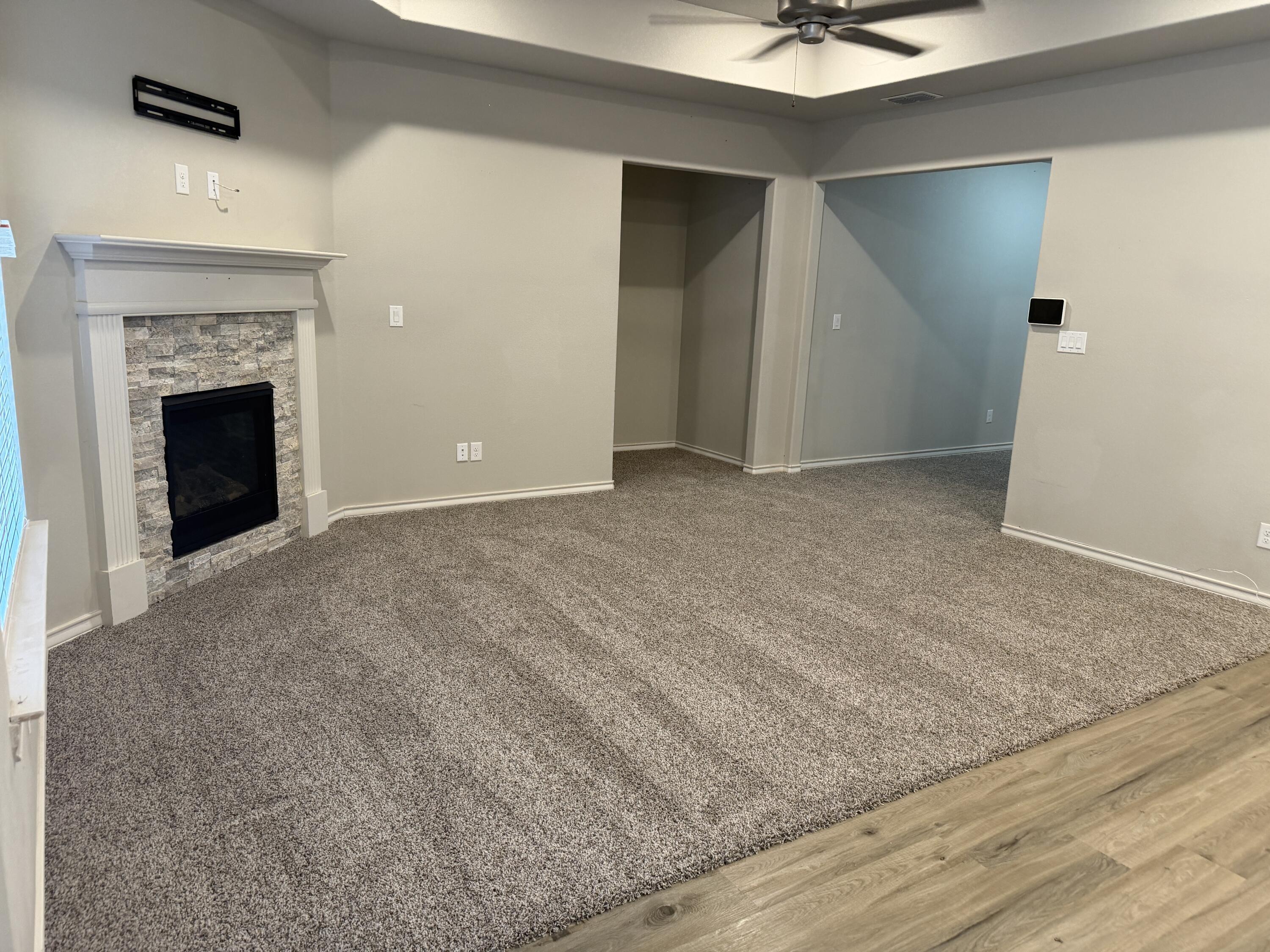 816 North 3rd Street Wolfforth, TX 79382 - Photo 2 of 28 an empty room with fan and a fireplace