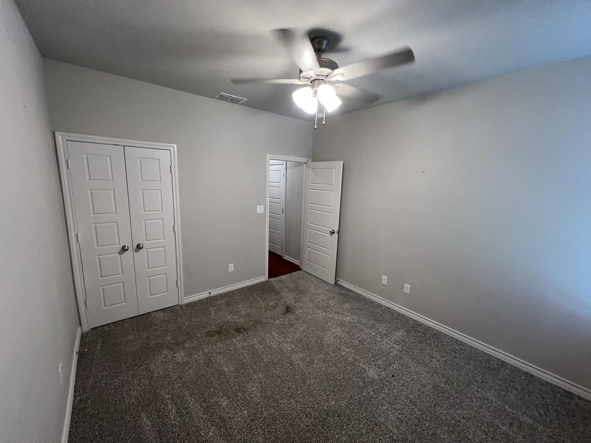 816 North 3rd Street Wolfforth, TX 79382 - Photo 23 of 28 an empty room with a chandelier fan and a chandelier fan