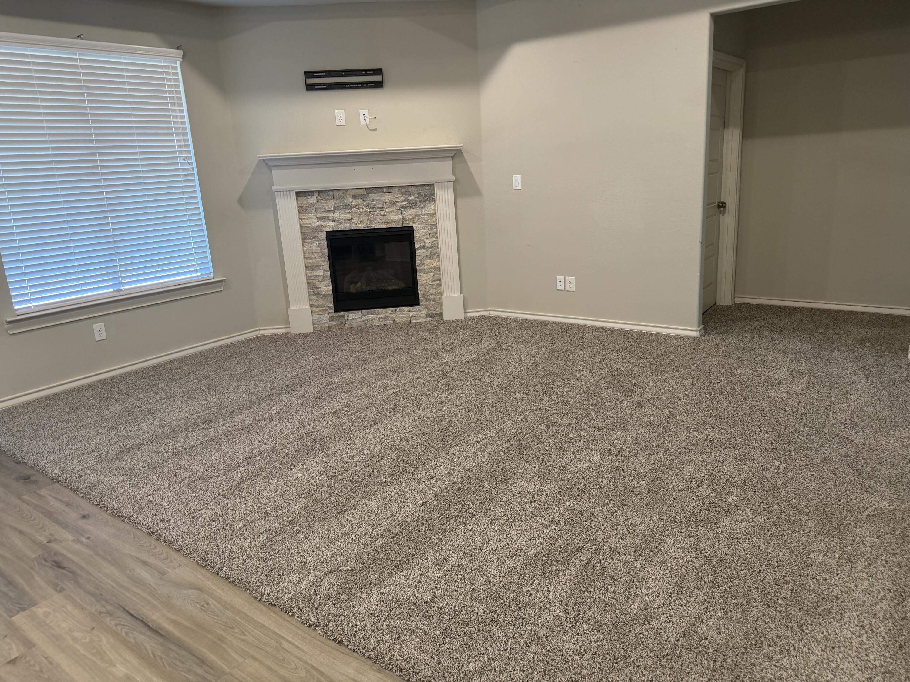 816 North 3rd Street Wolfforth, TX 79382 - Photo 3 of 28 an empty room with fireplace and window