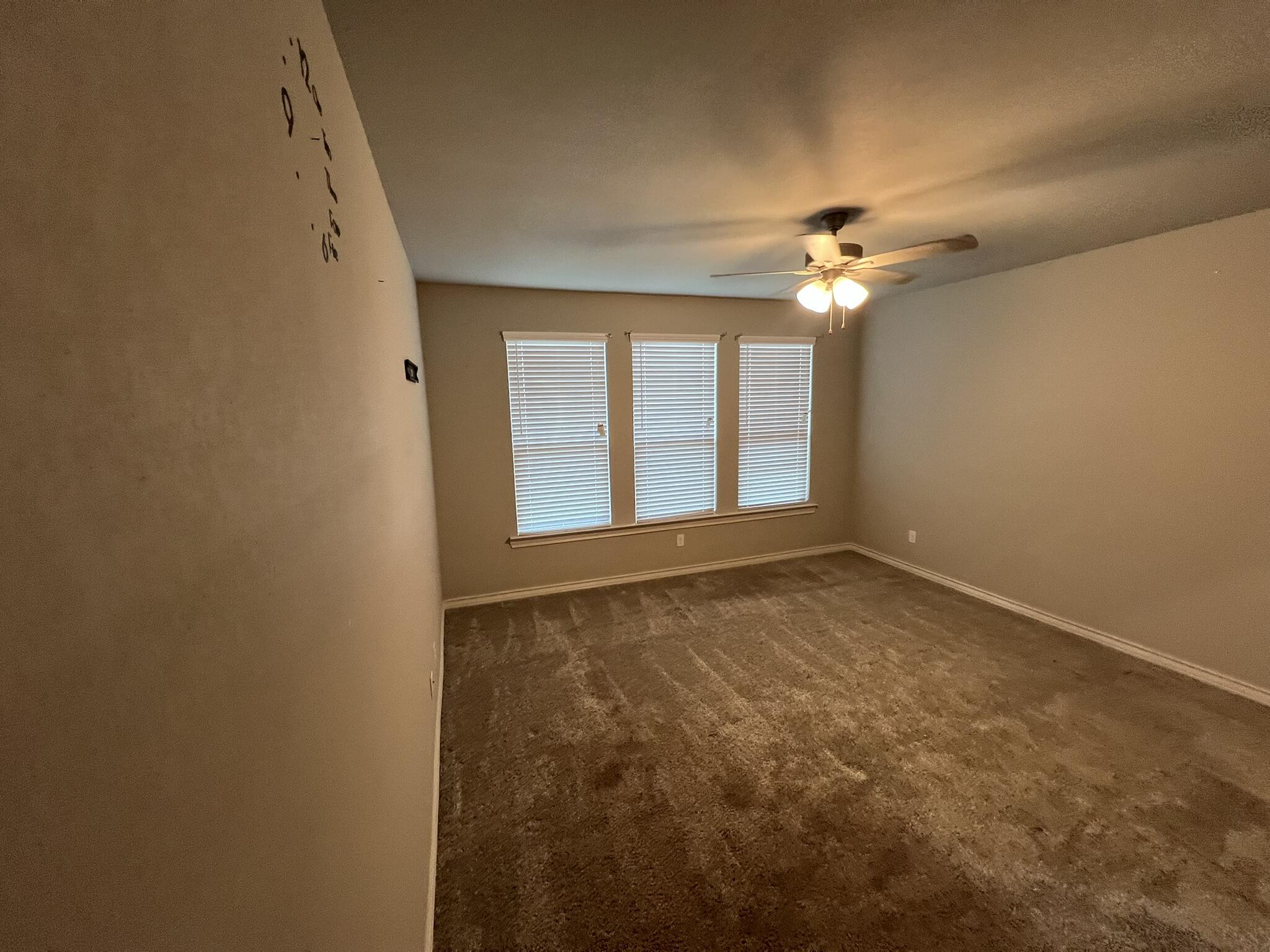816 North 3rd Street Wolfforth, TX 79382 - Photo 9 of 28 an empty room with windows and fan