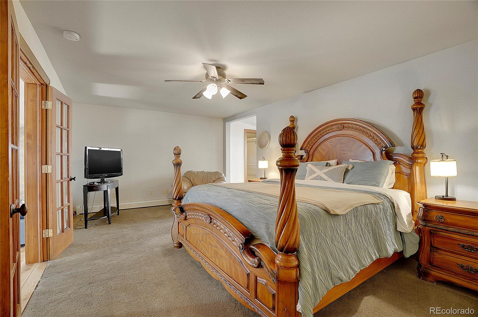468 Riverside Drive Lyons, CO 80540 - Photo 20 of 50 a bedroom with a bed and a flat screen tv