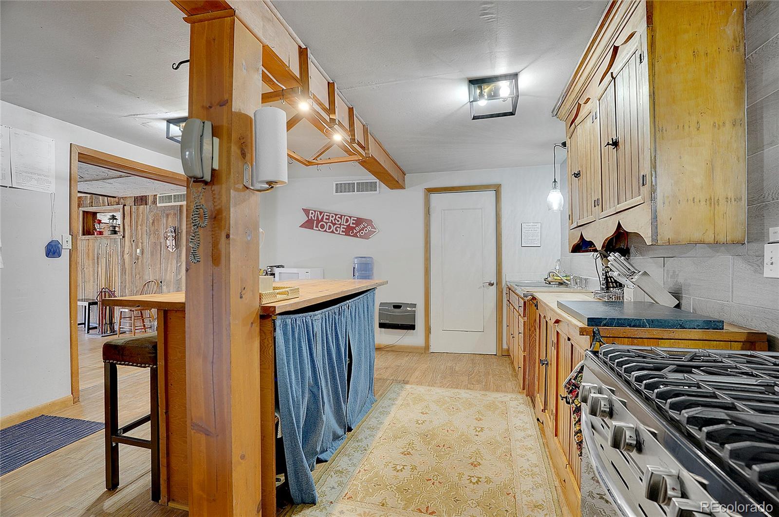 468 Riverside Drive Lyons, CO 80540 - Photo 45 of 50 a kitchen with stainless steel appliances granite countertop a stove and a wooden cabinets