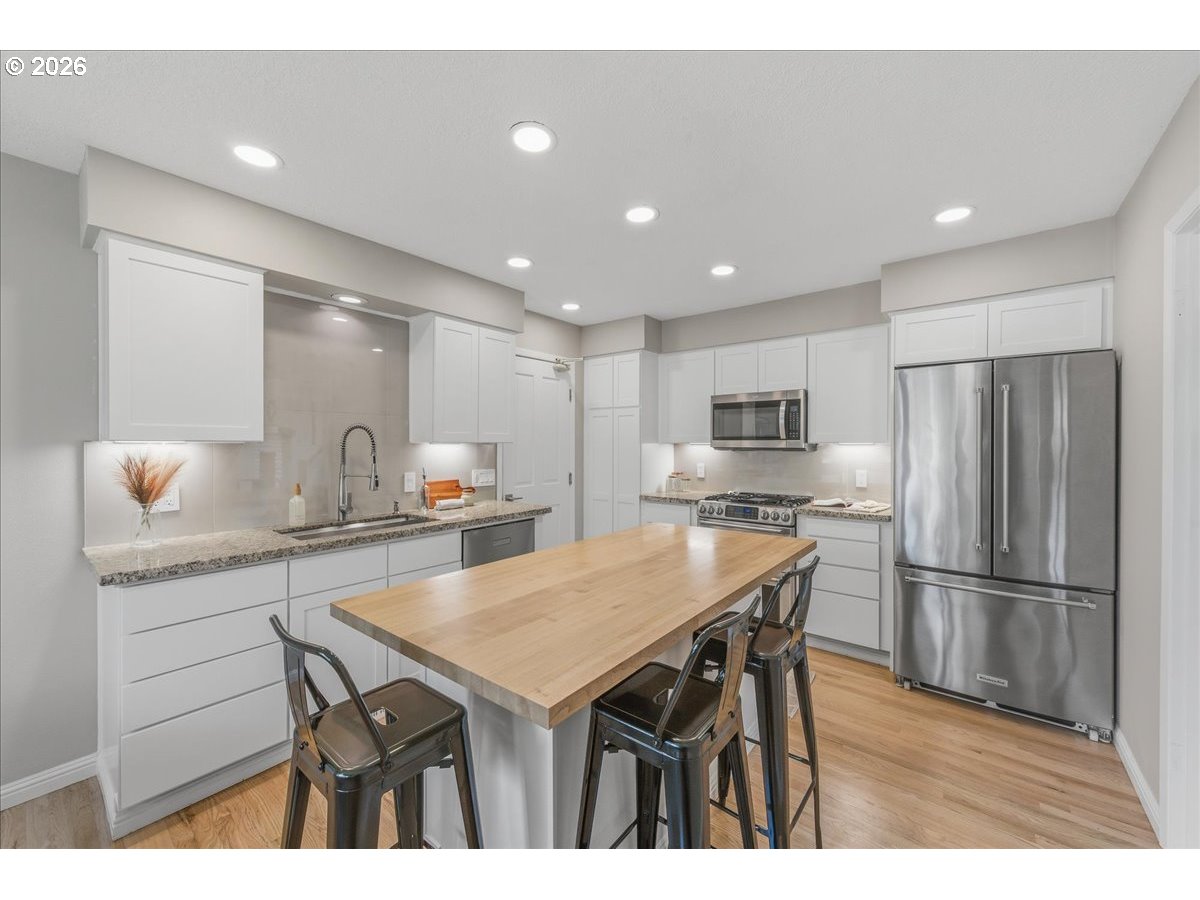 3130 Southwest 116th Avenue Beaverton, OR 97005 - Photo 12 of 44 a kitchen with a sink a refrigerator and wooden floor