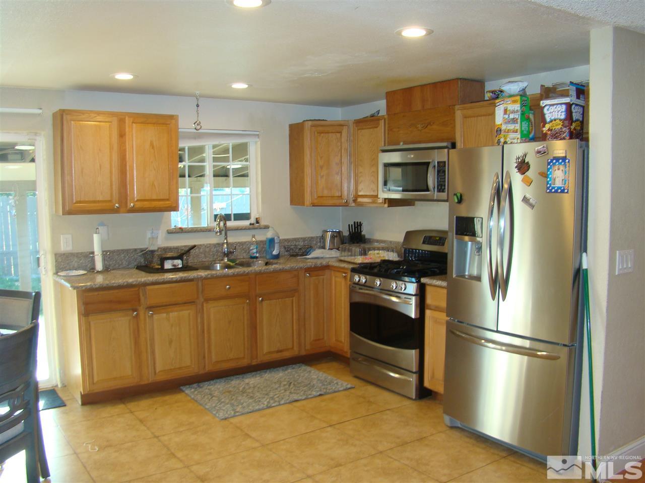 13011 Exinite Drive Reno, NV 89506 - Photo 5 of 10 a kitchen with stainless steel appliances granite countertop a refrigerator a stove top oven a sink and dishwasher