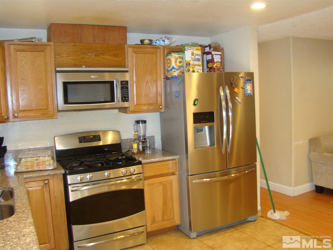 13011 Exinite Drive Reno, NV 89506 - Photo 7 of 10 a kitchen with stainless steel appliances granite countertop a refrigerator and a stove top oven