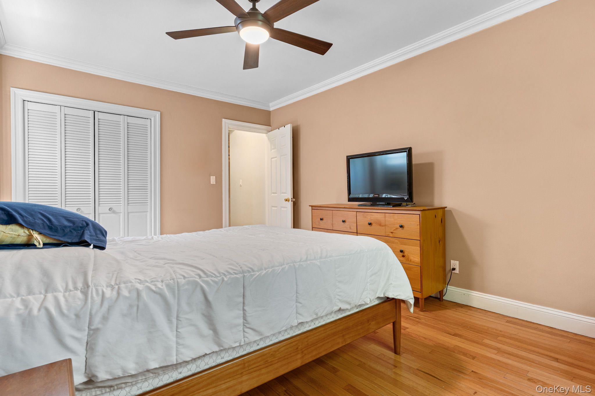 755 Bronx River Road, Unit 4B Bronxville, NY 10708 - Photo 18 of 27 Bedroom featuring wood-finish flooring, crown molding, and two windows with natural light