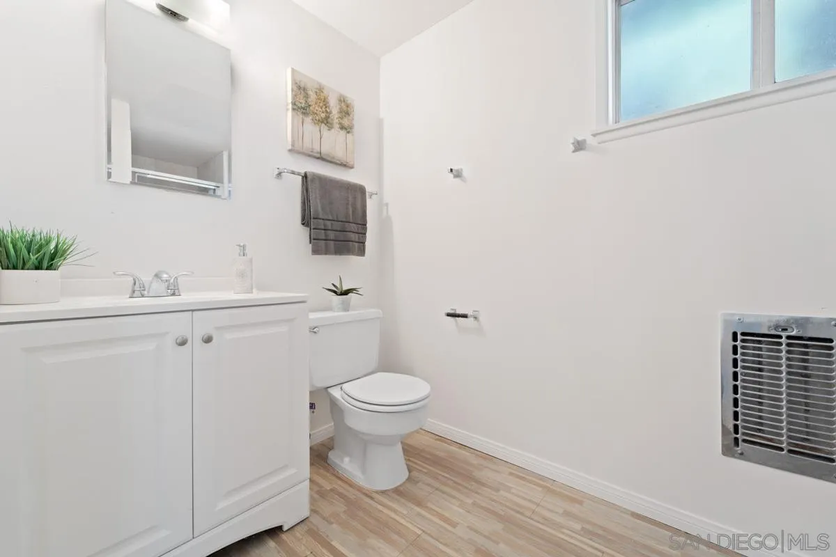 4276 Orchard Drive Spring Valley, CA 91977 - Photo 16 of 19 a bathroom with a toilet sink a mirror and vanity