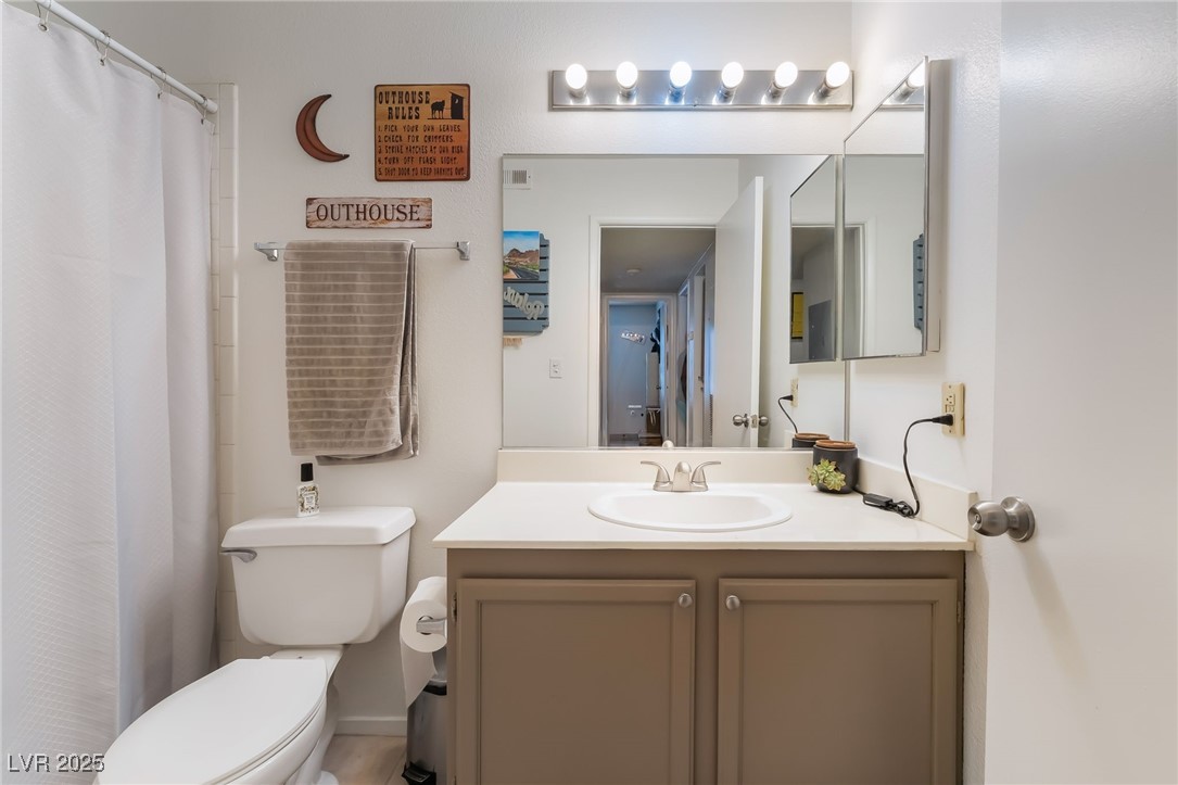 1575 West Warm Springs Road, Unit 2822 Henderson, NV 89014 - Photo 33 of 37 Full bathroom featuring toilet, vanity, and a shower with shower curtain