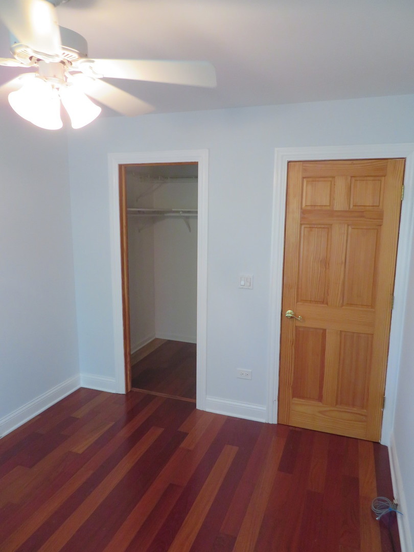 457 North Cambridge Drive, Unit 457 Palatine, IL 60067 - Photo 21 of 31 an empty room with wooden floor and closet area