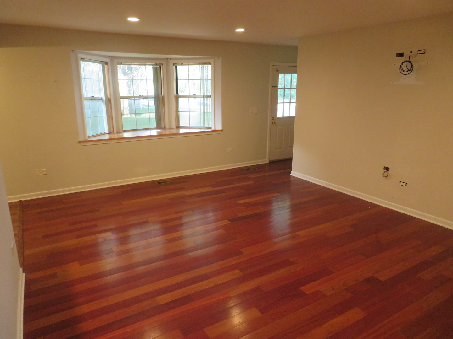 457 North Cambridge Drive, Unit 457 Palatine, IL 60067 - Photo 6 of 31 an empty room with wooden floor and windows