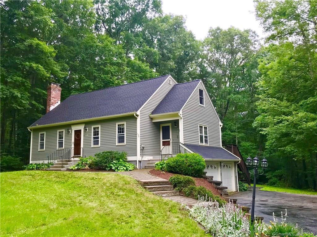 a front view of a house with a yard and trees